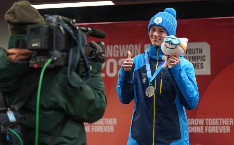 1月23日，在江原道平昌郡阿尔卑西亚滑行中心举办的2024年江原冬季青年奥林匹克运动会男子俯式冰橇颁奖典礼上，乌克兰选手雅罗斯拉夫·拉夫列纽克手持本届冬青奥会吉祥物“萌吉奥”合影留念。图片来源：国际奥委会奥林匹克信息服务（OIS）