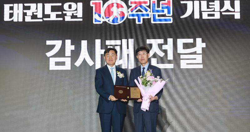 图为，全罗北道特别自治道知事金宽永（左）向跆拳道振兴财团代理理事长李钟甲（音）转达感谢牌。图片来源：全罗北道特别自治道厅