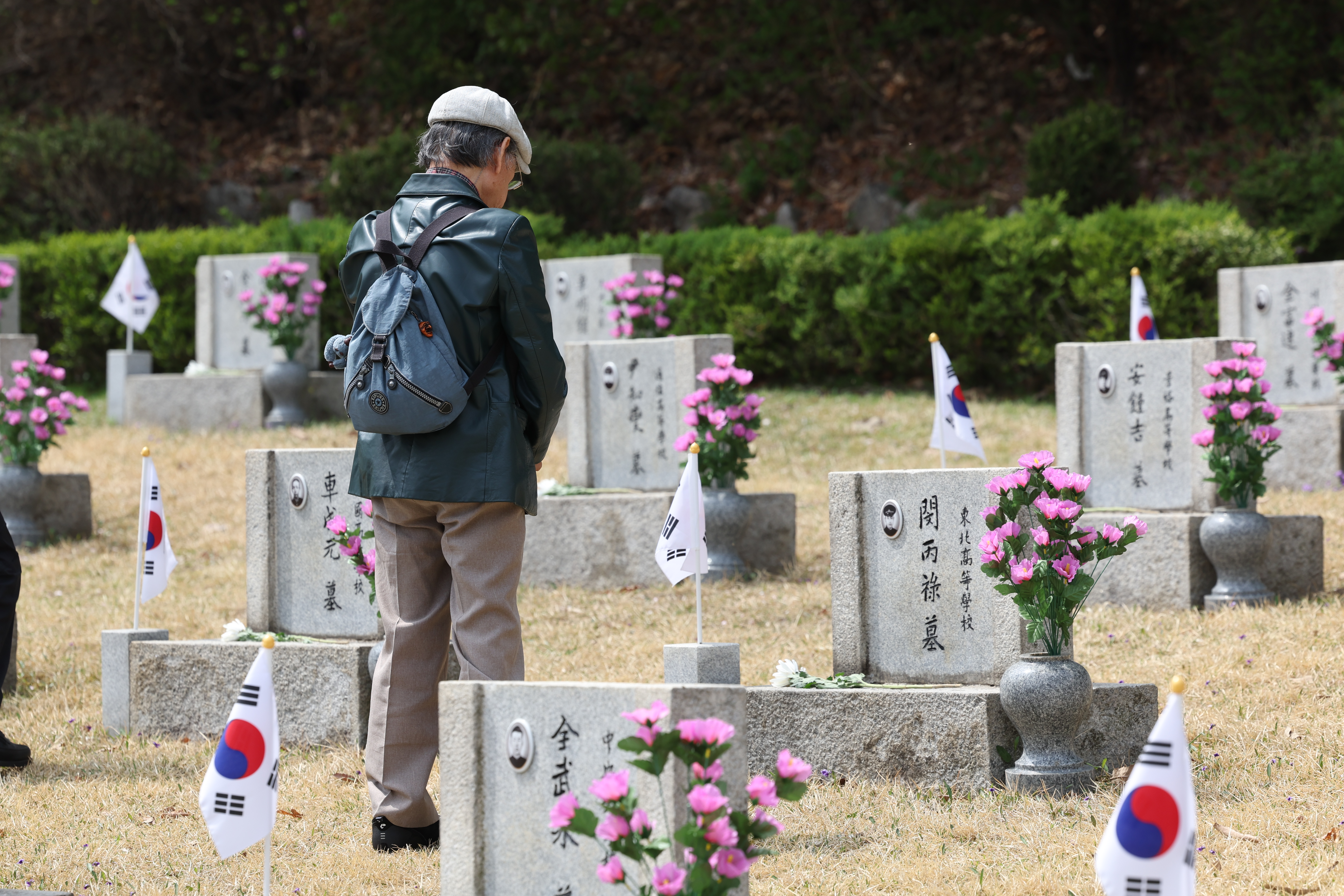 4月18日，在首尔江北区的国立四一九民主公墓，一位牺牲者遗属正在墓前默哀。