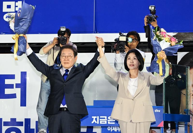6月4日，在首尔汝矣岛国会附近，韩国共同民主党总统候选人李在明（左）在确定当选新任总统后，与夫人金惠景高举双手向市民致意。图片来源：韩联社 