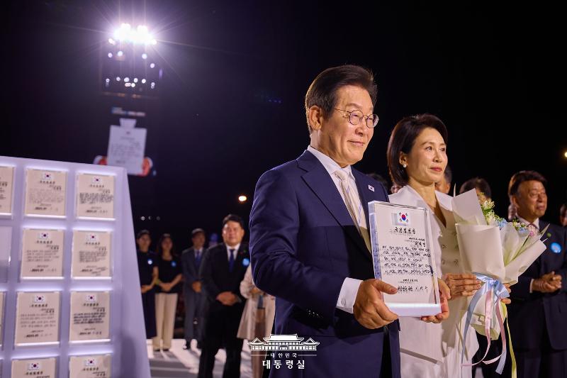 8月15日，韩国总统李在明与第一夫人金惠景在首尔世宗大路光化门广场出席第21届总统国民任命仪式，并接受国民代表80人授予的“国民任命状”。图片来源：大韩民国总统室