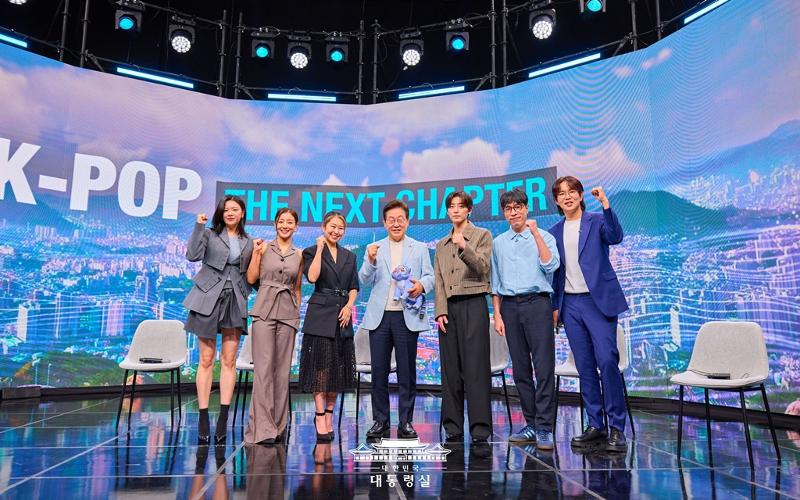 8月20日，韩国总统李在明做客阿里郎电视台节目《K-Pop：The Next Chapter》并与嘉宾合影留念。左起依次为女团TWICE成员志效和定延、奈飞（Netflix）动画片《K-POP：猎魔女团》导演玛吉·康、李在明、音乐制作人兼DJ“R.Tee”、音乐评论家金永大（音）和主持人张成圭。图片来源：大韩民国总统室