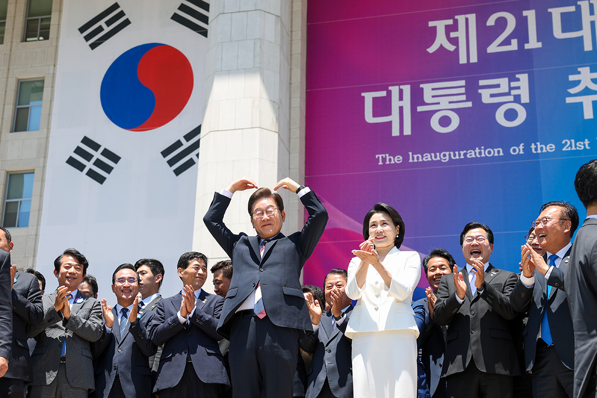 图为去年6月4日，韩国总统李在明与夫人金惠景在国会结束就职典礼后，并向民众比心致意。韩宣网记者李廷佑 摄