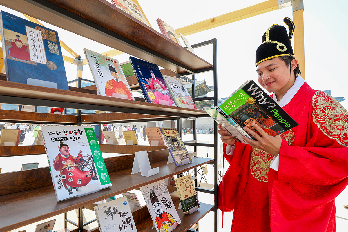 5月15日，在首尔钟路区景福宫兴礼门广场举行的&ldquo;世宗大王诞辰629周年&rdquo;纪念活动中，一位外国游客正在翻阅与世宗大王相关的书籍。