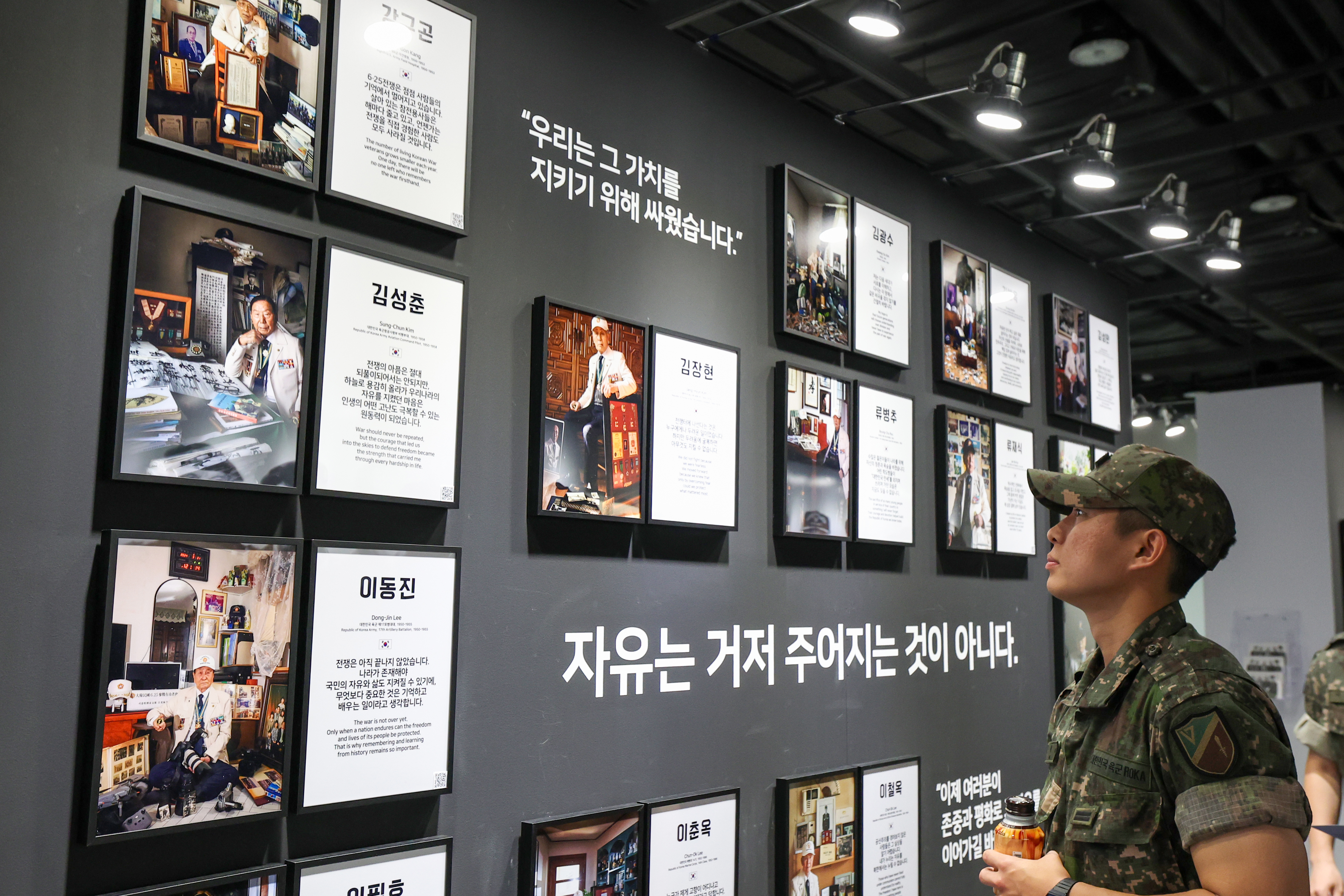 6月19日，在首尔市龙山区战争纪念馆举行的《韩国战争老兵致敬摄影展》上，一名官兵正在观看老兵肖像作品。韩宣网记者李廷佑 摄