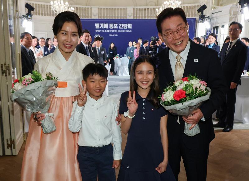 当地时间6月9日，韩国总统李在明（右）与夫人金惠景在比利时布鲁塞尔一家酒店举行的韩侨座谈会上，与花童合影留念。图片来源：韩联社