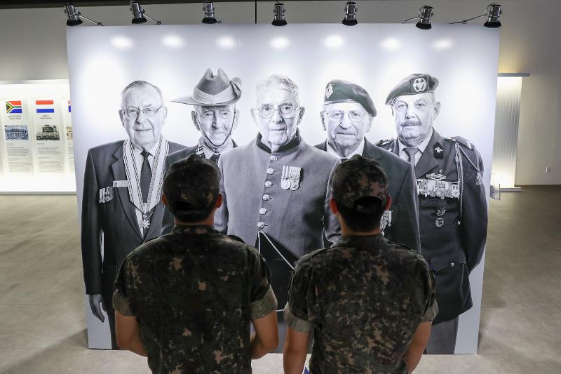 6月19日，在首尔市龙山区战争纪念馆举行的《韩国战争老兵致敬摄影展》上，前来参观的官兵正在观看老兵肖像作品。韩宣网记者李廷佑 摄