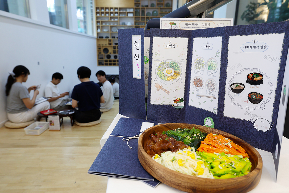 7月9日，在首尔钟路区韩食文化空间&ldquo;二音&rdquo;举行的&ldquo;韩食游乐场：将韩食融入屏风&rdquo;体验活动中，市民在屏风上绘制韩国美食，感受韩食文化的魅力。