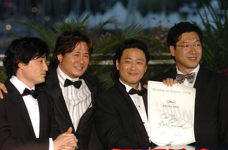 图为当地时间2004年5月22日，在法国戛纳举行的第57届戛纳国际电影节颁奖典礼上，韩国电影《老男孩》荣获评委会大奖。从左至右依次为该片制片人林承龙（音）、演员崔岷植、导演朴赞郁、摄影导演郑正勋。图片来源：戛纳国际电影节